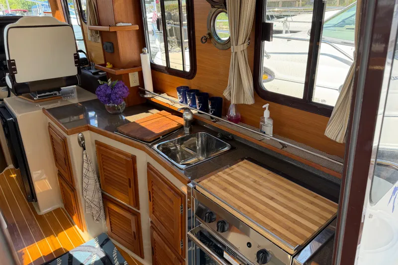 Slide: The Image of Interior of 2017 Ranger Tugs R-31 S boat with kitchen amenities and wooden cabinetry. - 12