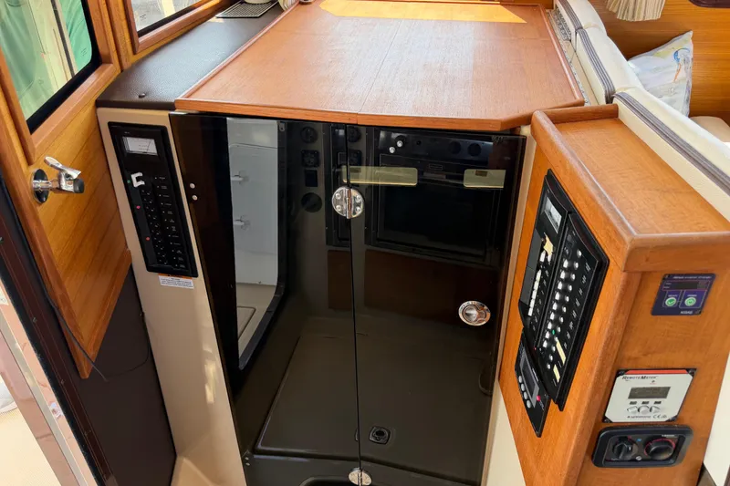 Slide: The Image of 2017 Ranger Tugs R-31 S interior with control panels and wooden cabinetry. - 49