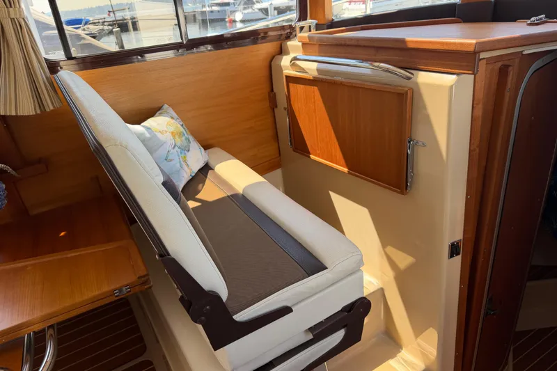 Slide: The Image of Interior of 2017 Ranger Tugs R-31 S with cushioned seating and wooden accents. - 18