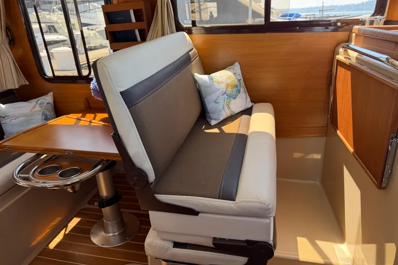 Slide: The Image of Interior of 2017 Ranger Tugs R-31 S with cushioned seating and wooden accents. - 19