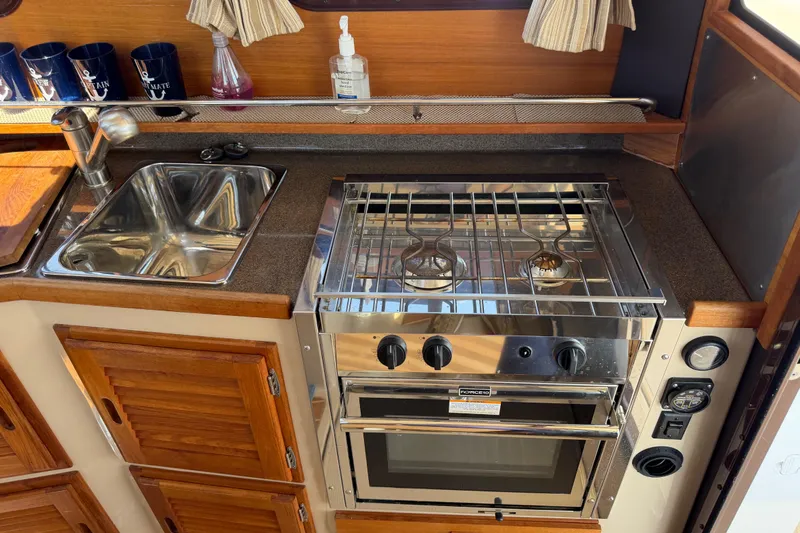 Slide: The Image of 2017 Ranger Tugs R-31 S galley with stainless steel sink and stove. - 14