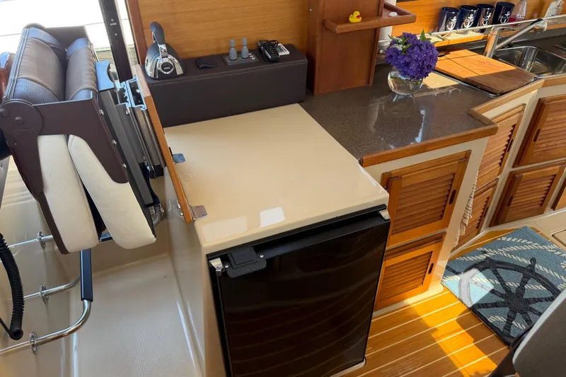 Slide: The Image of Interior of 2017 Ranger Tugs R-31 S with compact kitchen and wooden cabinetry. - 25