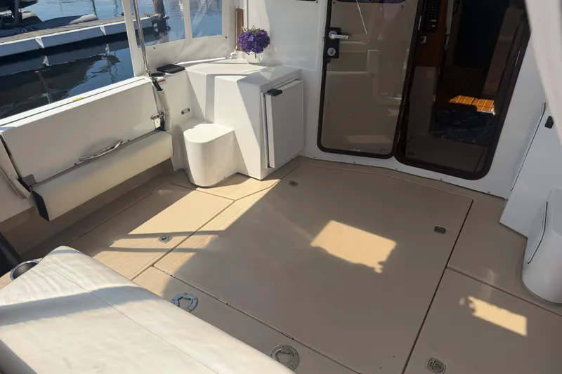 Slide: The Image of 2017 Ranger Tugs R-31 S boat interior with seating and table, docked at marina. - 2