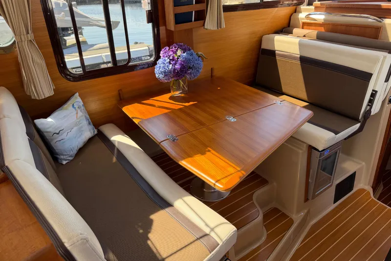 Slide: The Image of Interior of 2017 Ranger Tugs R-31 S with wooden table and seating area. - 23
