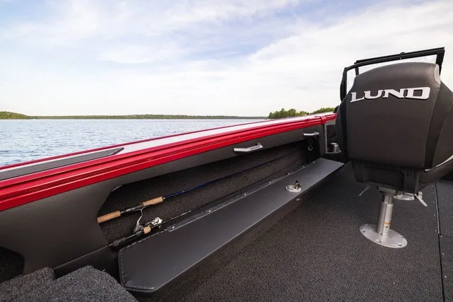 Slide: The Image of The image shows the interior of a Lund 2275 Tyee Sport boat with a red railing. - 8