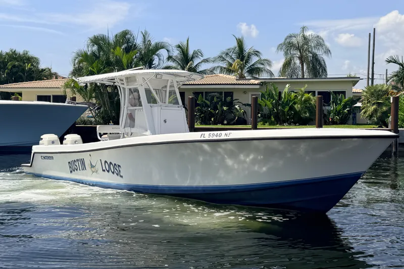 Slide: The Image of 2006 Contender 31 Open boat cruising on water near tropical waterfront homes. - 6