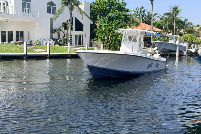Slide: The Image of 2006 Contender 31 Open boat cruising near waterfront homes with palm trees. - 12