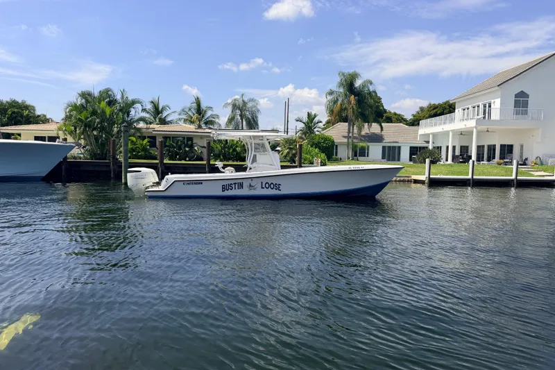 Slide: The Image of 2006 Contender 31 Open boat docked by waterfront homes, sunny day. - 10