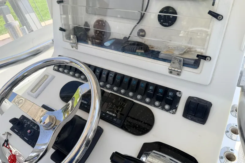 Slide: The Image of Control panel of a 2006 Contender 31 Open boat with steering wheel and switches. - 17