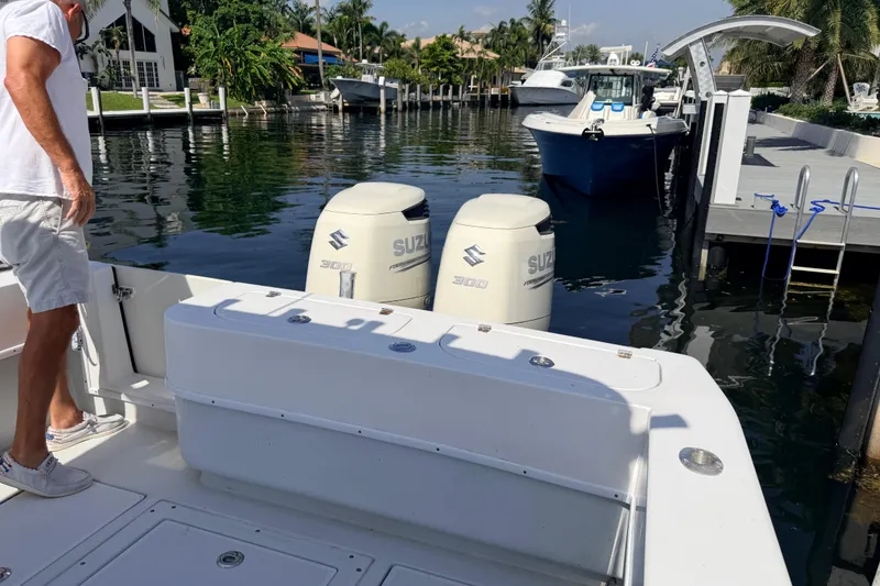 Slide: The Image of 2006 Contender 31 Open boat with Suzuki engines docked in a scenic marina. - 29