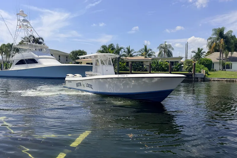 Slide: The Image of 2006 Contender 31 Open boat cruising on a sunny day near waterfront homes. - 9
