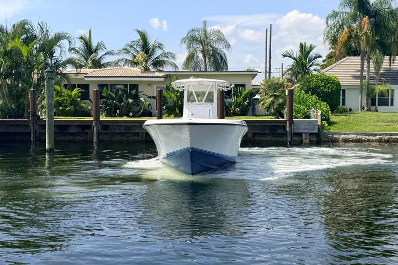Slide: The Image of 2006 Contender 31 Open boat cruising near waterfront homes with palm trees. - 4