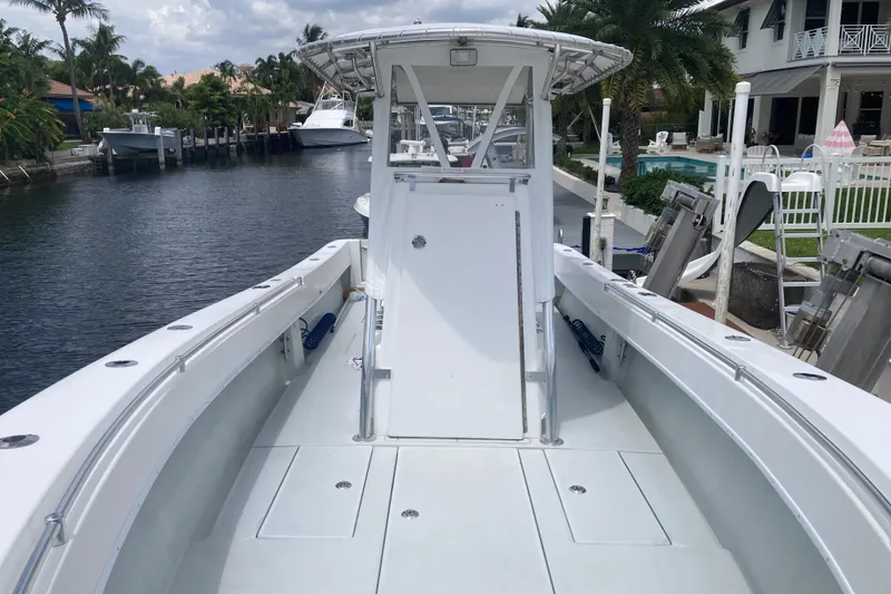 Slide: The Image of 2006 Contender 31 Open boat docked by waterfront homes, showcasing spacious deck and sleek design. - 17