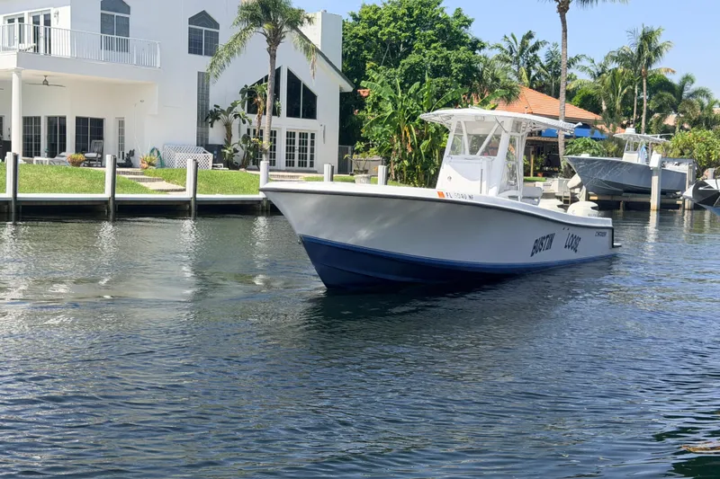 Slide: The Image of 2006 Contender 31 Open boat cruising near waterfront homes with palm trees. - 15