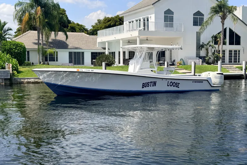 Slide: The Image of 2006 Contender 31 Open boat docked by a waterfront house. - 14