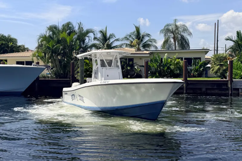 Slide: The Image of 2006 Contender 31 Open boat cruising near a tropical waterfront home. - 5