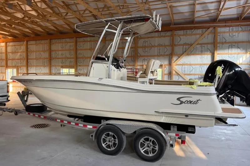 Slide: The Image of 2019 Scout 215 XSF boat on trailer in a wooden garage. - 0