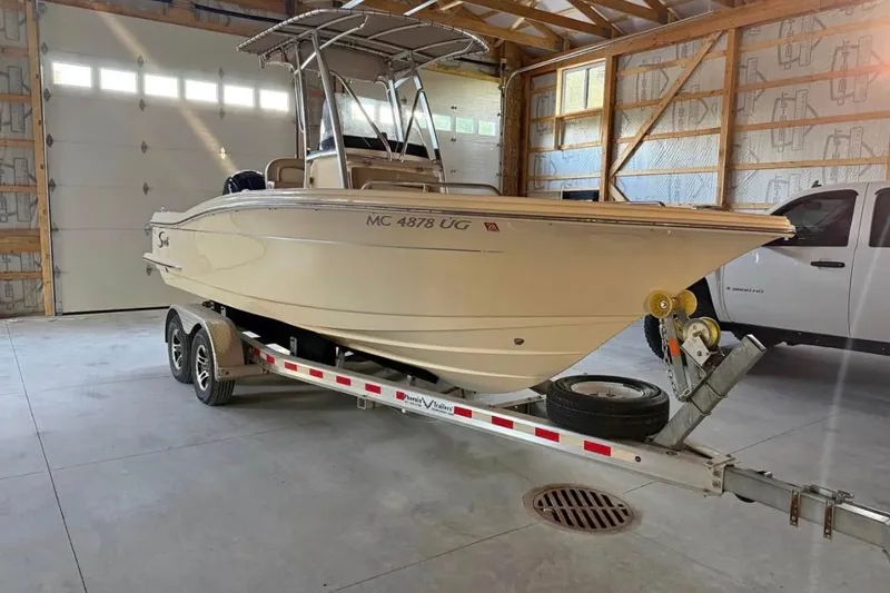 Slide: The Image of 2019 Scout 215 XSF boat on trailer in garage setting. - 3