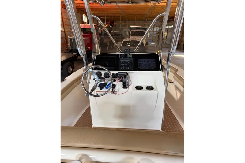 Slide: The Image of 2019 Scout 215 XSF boat console with steering wheel and controls in a garage setting. - 6