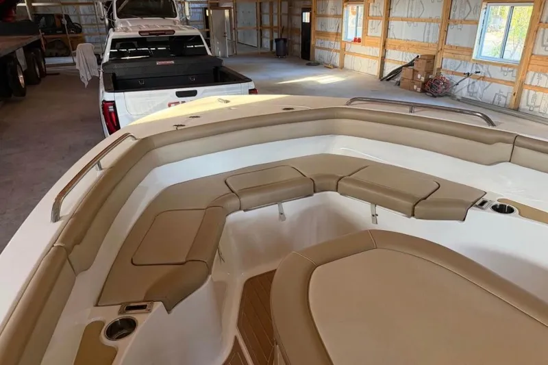 Slide: The Image of 2019 Scout 215 XSF boat interior with tan seating in a spacious garage. - 9