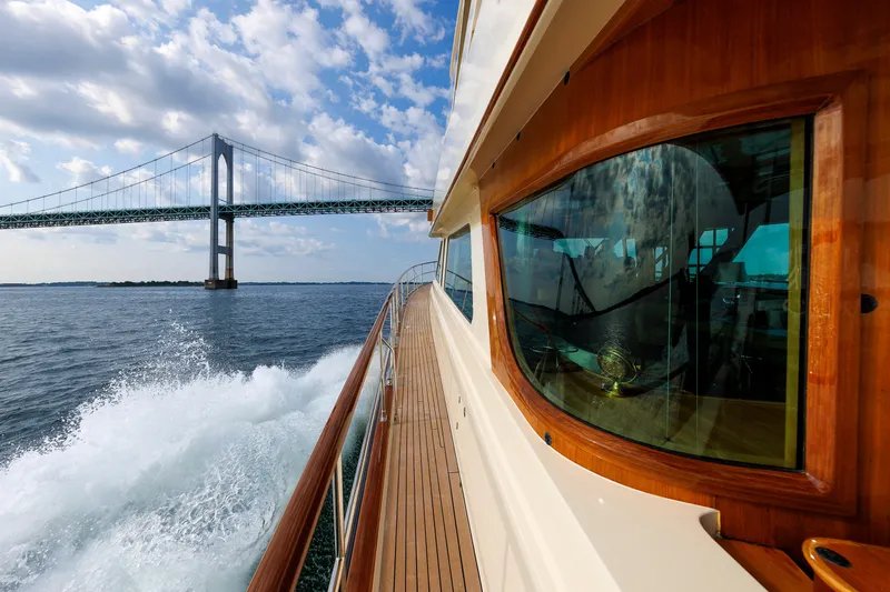 Slide: The Image of Hunt Yachts 72 FB cruising under a bridge, showcasing elegant design and craftsmanship. - 59
