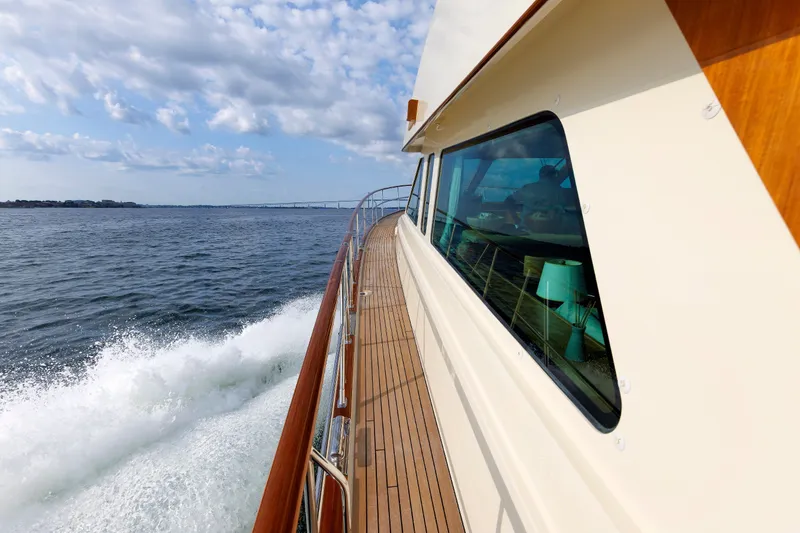 Slide: The Image of Hunt Yachts 72 FB 2016 cruising on open water, showcasing sleek design and wooden deck. - 60