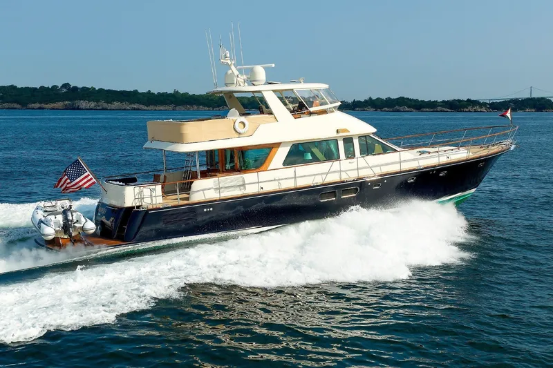 The Image of An elegant motor yacht speeds across the water, with a small tender at the stern. - 0