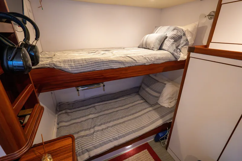 Slide: The Image of Bunk beds in 2016 Hunt Yachts Ocean Series 72FB cabin, featuring striped bedding and wooden accents. - 65
