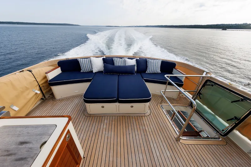 Slide: The Image of Luxurious 2016 Hunt Yachts 72 FB deck with blue seating, cruising on open water. - 48