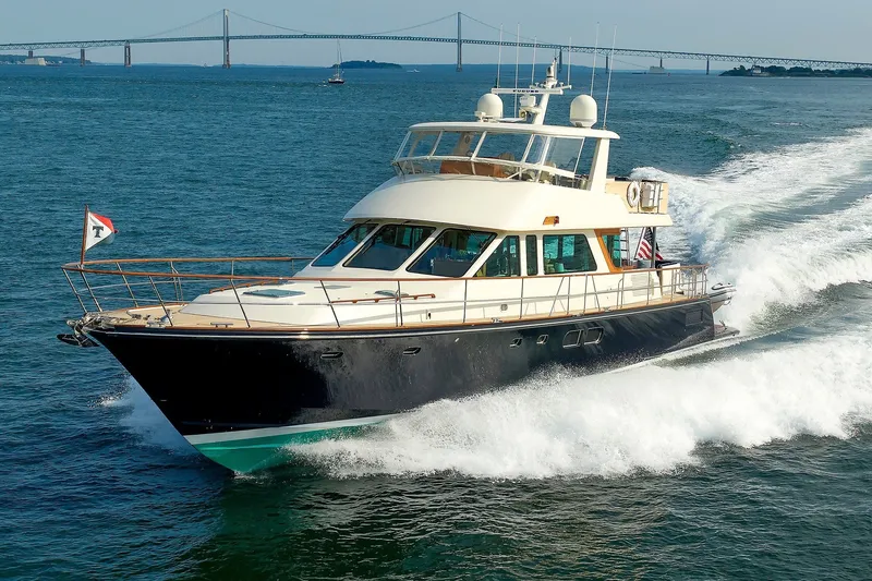 Slide: The Image of Luxury 2016 Hunt Yachts 72 FB cruising on open water with bridge in background. - 5