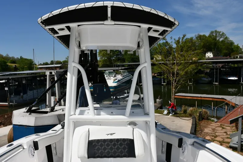 Slide: The Image of 2023 Tidewater 210 LXF boat docked at a marina with scenic background. - 13