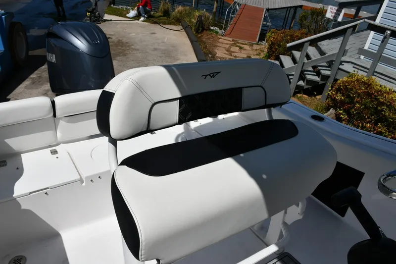 Slide: The Image of 2023 Tidewater 210 LXF boat interior with white and black seating, dockside view. - 19