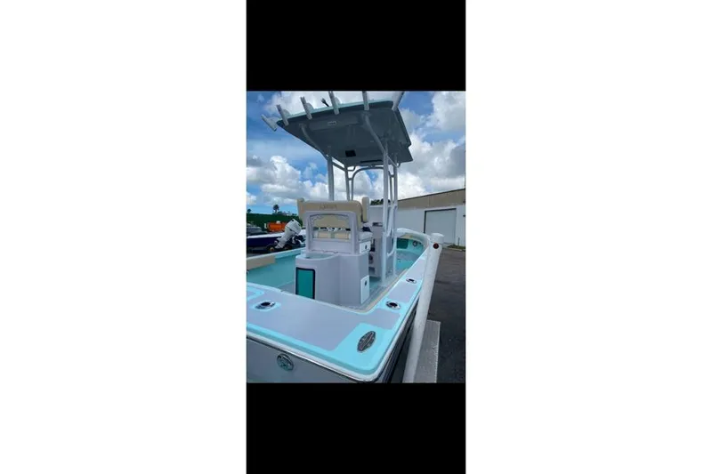 Slide: The Image of 2026 Exuma 22 boat with T-top, sleek design, and modern features under a cloudy sky. - 8