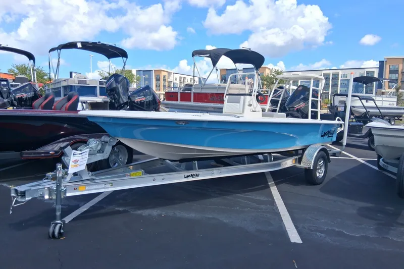 The Image of 2026 Mako 18 Pro Skiff boat on trailer in parking lot under blue sky. - 0