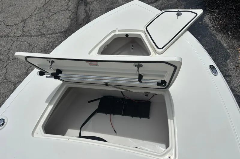 Slide: The Image of 2026 Mako 18 Pro Skiff boat storage compartments open on deck. - 10