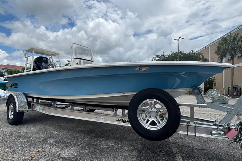 Slide: The Image of 2026 Mako 18 Pro Skiff boat on trailer, blue hull, parked outdoors. - 5