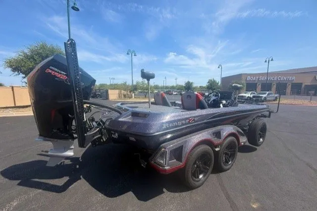 Slide: The Image of 2026 Ranger Z521 boat parked near a service center under a clear blue sky. - 3