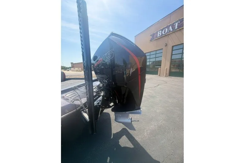 Slide: The Image of 2026 Ranger Z521 boat with powerful outboard motor, parked near a boat dealership. - 11