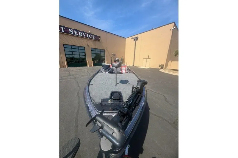 Slide: The Image of 2026 Ranger Z521 boat parked outside a service center under a clear blue sky. - 5