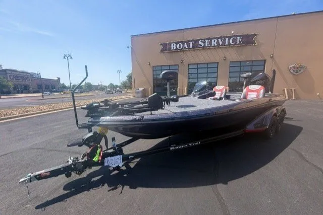 Slide: The Image of 2026 Ranger Z521 boat parked outside a boat service center on a sunny day. - 2