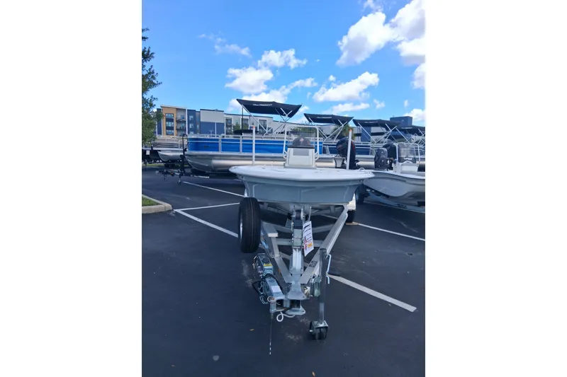Slide: The Image of 2026 Mako 18 Pro Skiff boat on trailer in parking lot under blue sky. - 3