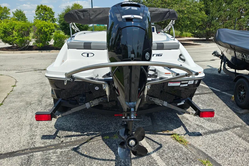 Slide: The Image of 2026 Tahoe T16 boat with Mercury outboard motor, parked on a trailer in a sunny setting. - 2