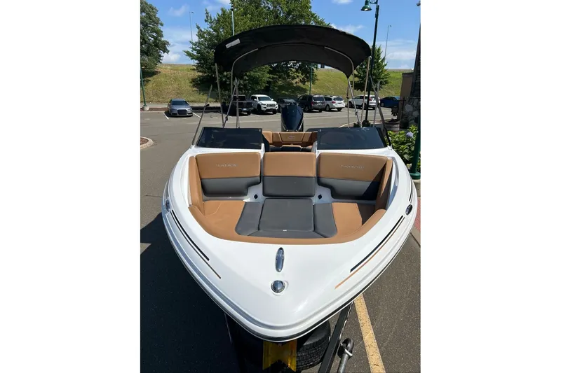 Slide: The Image of 2026 Tahoe 210 S boat with tan and gray seating, parked outdoors. - 3