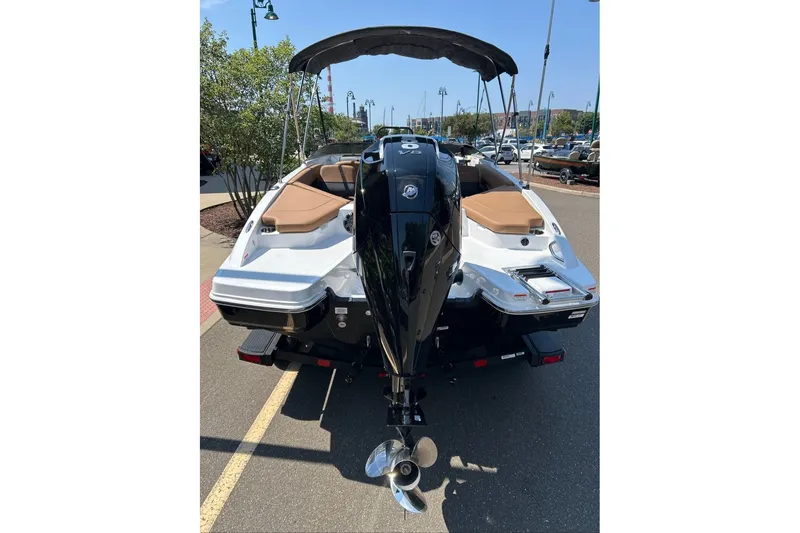 Slide: The Image of 2026 Tahoe 210 S boat with outboard motor, parked on a sunny day. - 2