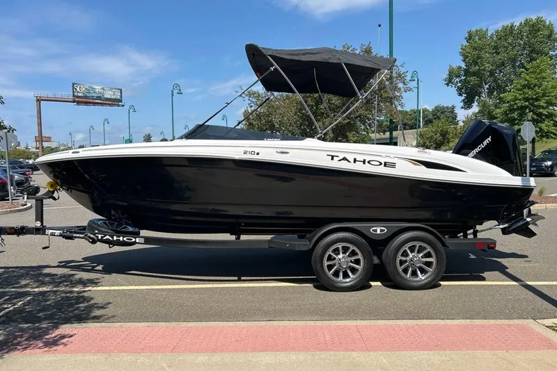 Slide: The Image of 2026 Tahoe 210 S boat on trailer, black and white design, parked outdoors. - 1