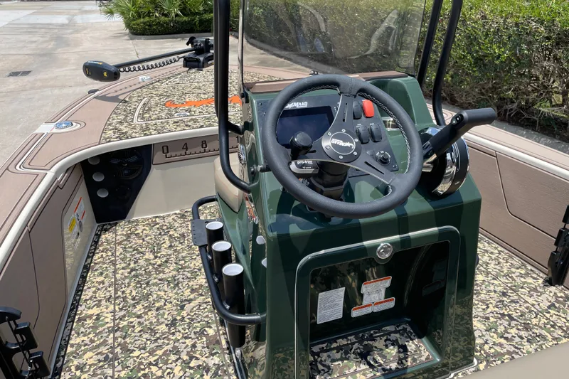 Slide: The Image of 2026 Mako 18 Pro Skiff Backwater Edition boat interior with camouflage design and steering console. - 10