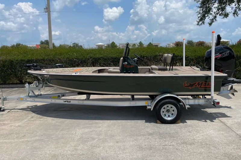The Image of 2026 Mako 18 Pro Skiff Backwater Edition boat on trailer, outdoors under blue sky. - 0