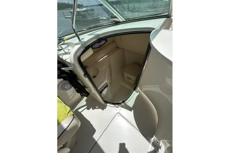 Slide: The Image of 2005 Sea Ray 270 Sundeck interior cabin view with open door, dockside background. - 12