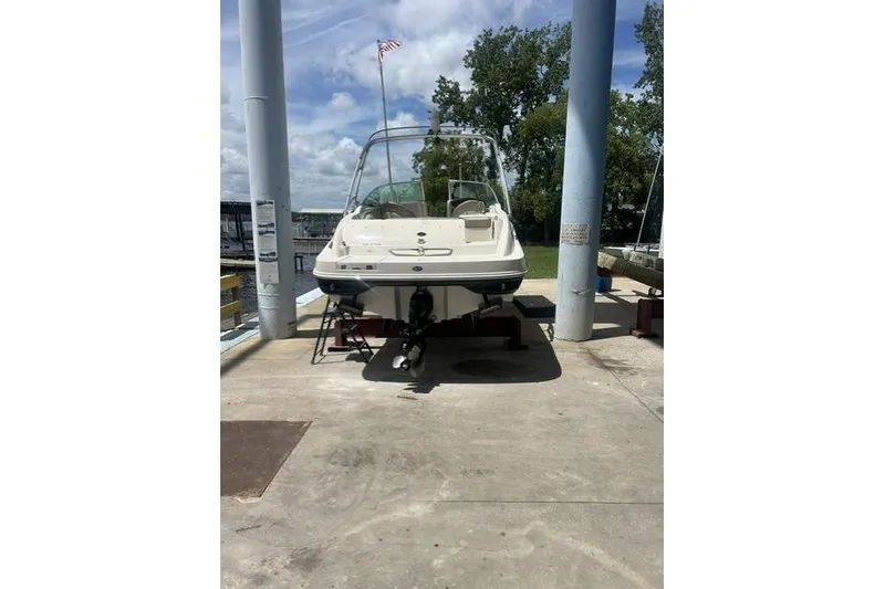 The Image of 2005 Sea Ray 270 Sundeck boat docked, rear view, under clear sky. - 1