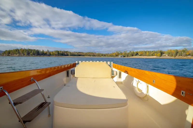 Slide: The Image of Hinckley Picnic Boat 36 Classic, 2001, cruising on a scenic lake under a blue sky. - 18